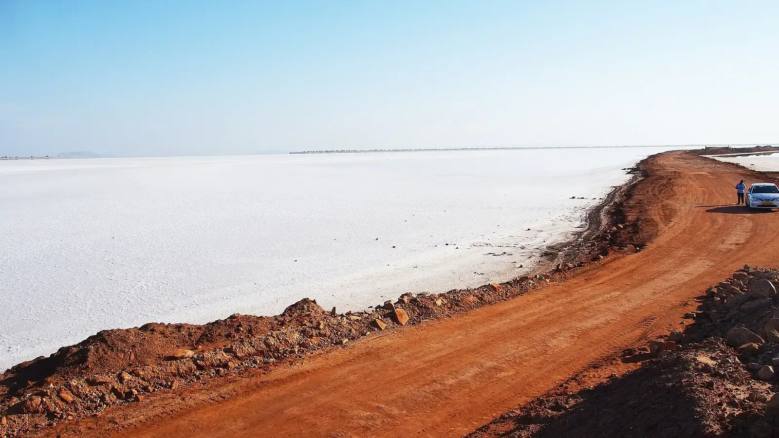 The white salt desert of the Rann of Kutch beside a red earth track