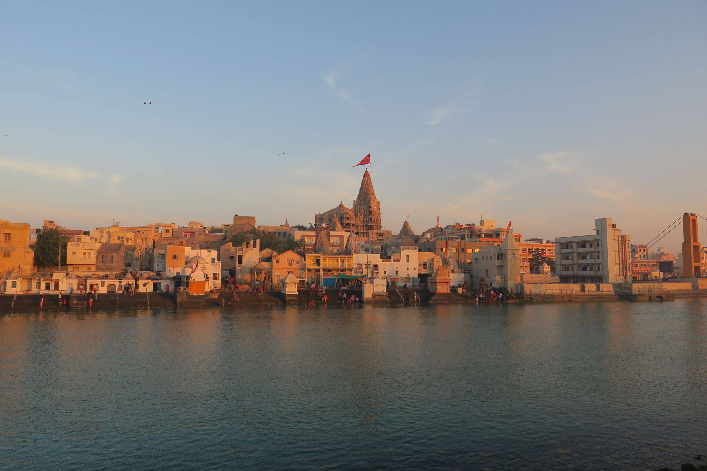 Dwarka at sunset, the Dwarkadhish temple spire above the town and the river