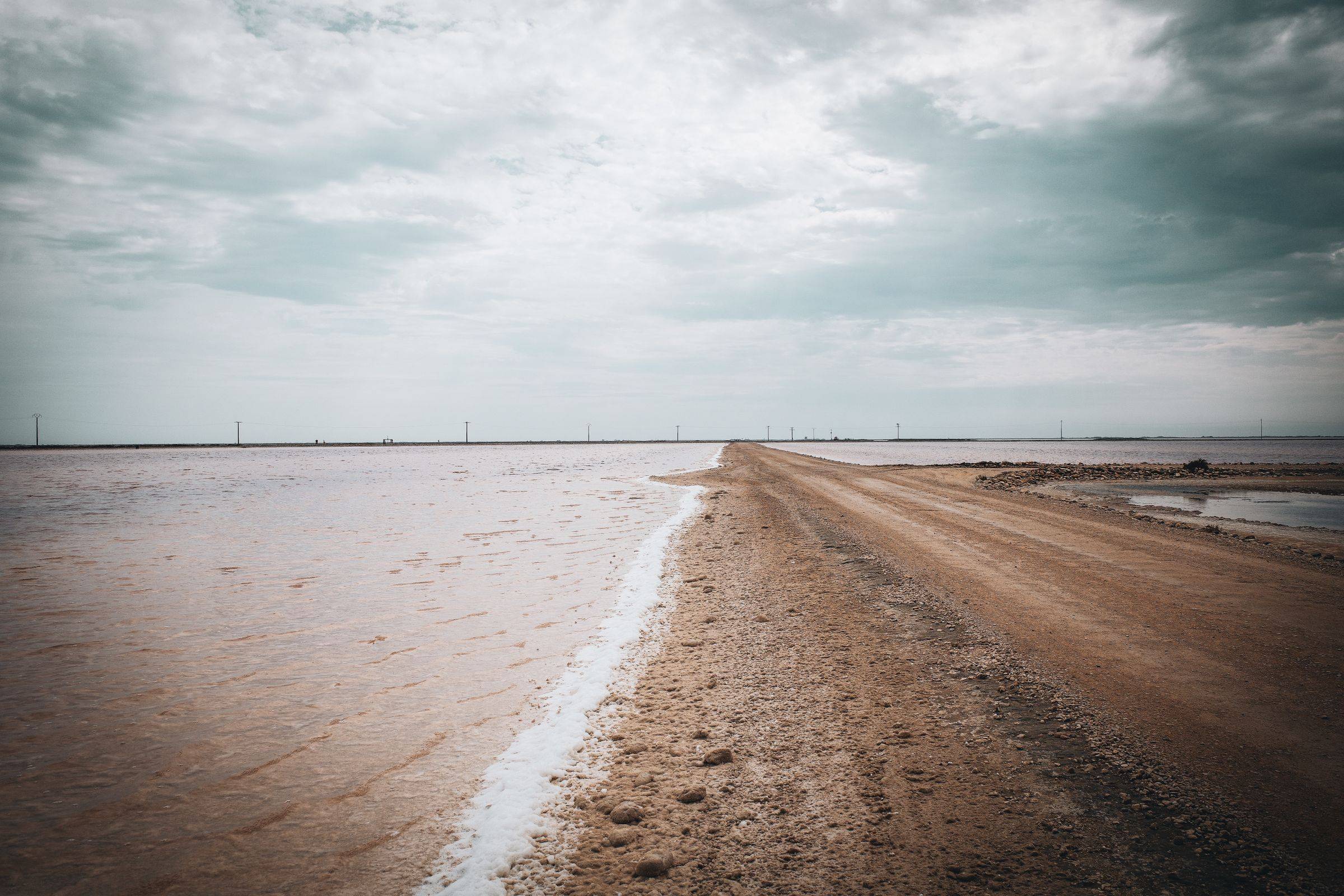 A dirt road running between the salt marshes of the Rann of Kutch