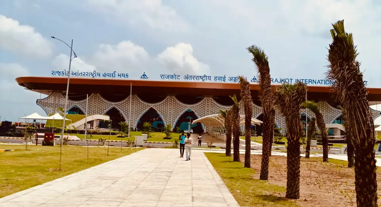 હીરાસર ખાતે રાજકોટ ઇન્ટરનેશનલ એરપોર્ટનું ટર્મિનલ, આગળના ભાગે ગુજરાતી, હિન્દી અને અંગ્રેજીમાં તેનું નામ
